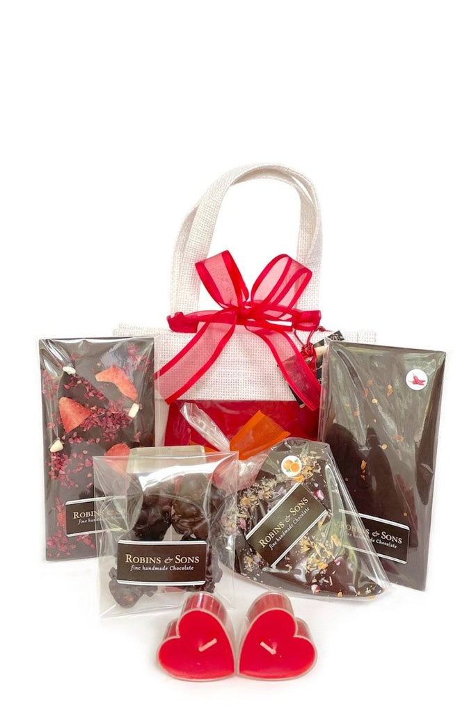 Dark chocolate ruby gift bag containing 2 full size Slim Bars (Very Berry, ChilliChoc), Nut Clusters, Orange Crackle Heart, 2 heart candle votives