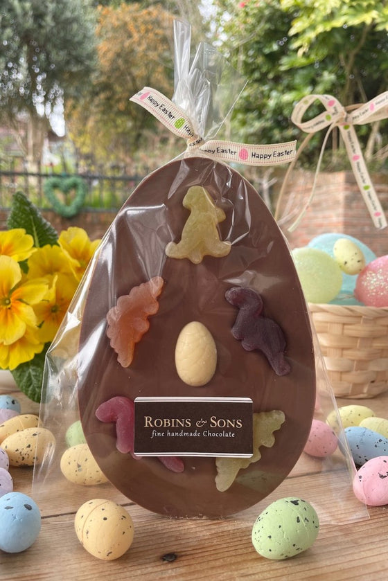 Dinosaur Easter EGg. Oval shaped milk chocolate bar topped with 5 fruit flavour dinosaur shapes and a white chocolate mini egglet