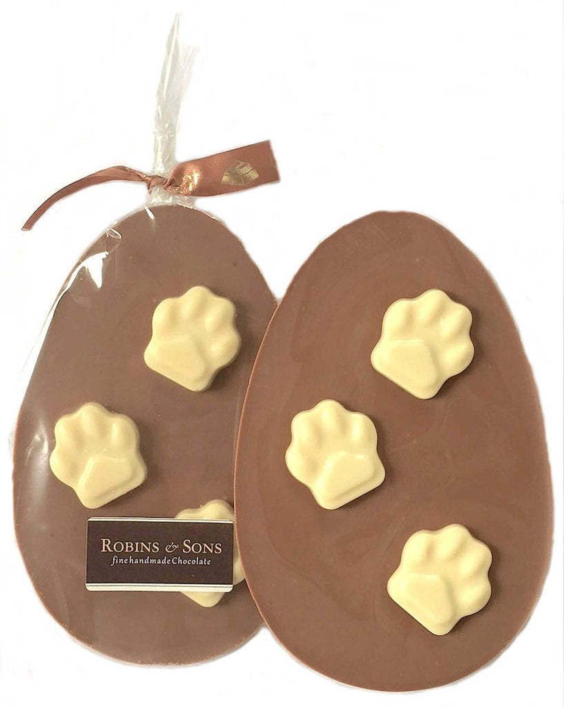 unpacked milk chocolate egg shaped bar topped with 3 white chocolate paw prints