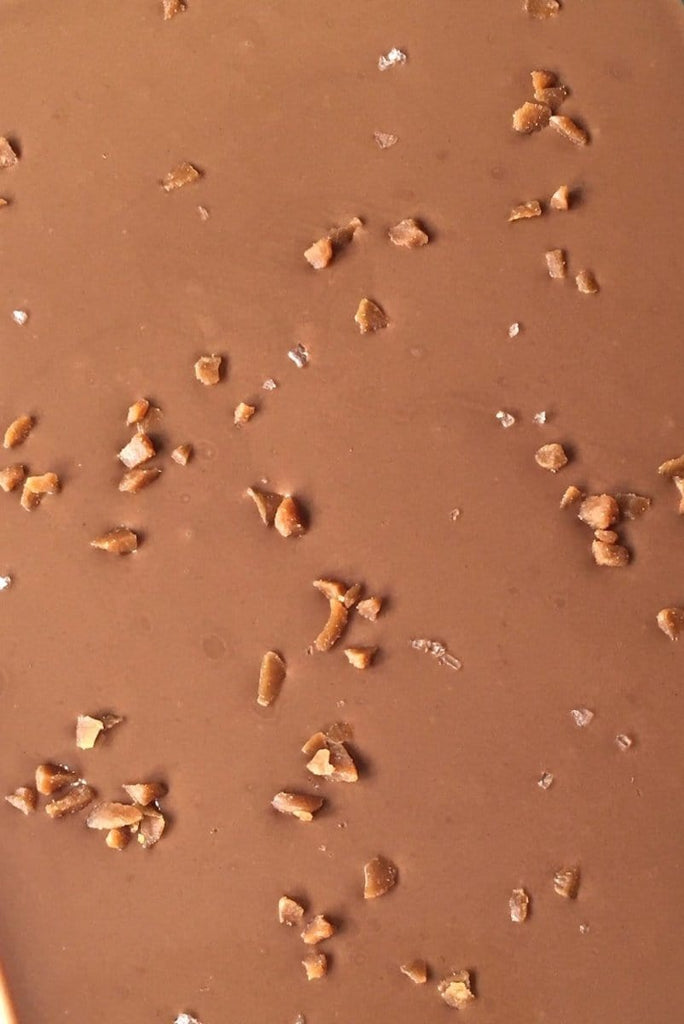 close up of Belgian milk chocolate with salted caramel pieces and sea salt flakes