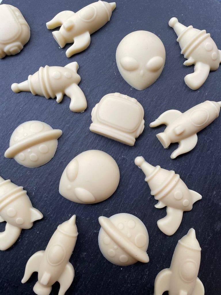 white chocolate space themed shapes including planets, rockets, rayguns, aliens