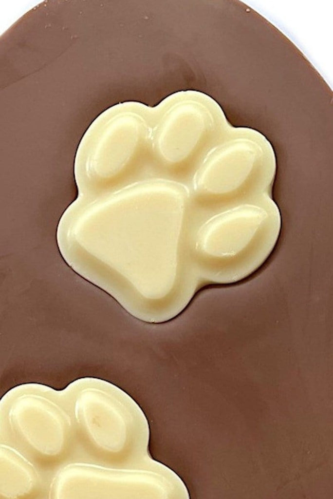 close up of solid white chocolate paw print - Paw prints easter egg